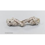 A white metal and diamond cluster set shaped bar brooch, 38mm, gross weight 4 grams.