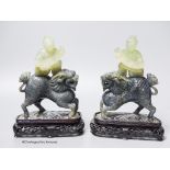 A pair of Chinese bowenite Jade figures of boys riding a qilin, mid 20th century, wood stands