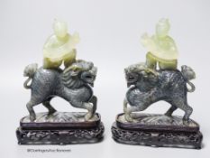A pair of Chinese bowenite Jade figures of boys riding a qilin, mid 20th century, wood stands