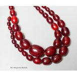 A double strand simulated oval cherry amber bead choker necklace (string broken), 44cm, gross