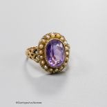 A 19th century yellow metal, amethyst and seed pearl set oval cluster dress ring, size N, gross 3.8