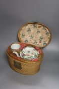 A Chinese teapot and two tea bowls, in carrying basket