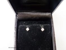 A modern pair of 18ct white gold and solitaire diamond set ear studs, gross weight 1.1 grams, each