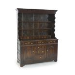 An 18th century oak dresser,The rack with moulded cornice and three fixed shelves incorporating six