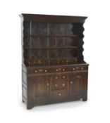 An 18th century oak dresser,The rack with moulded cornice and three fixed shelves incorporating six