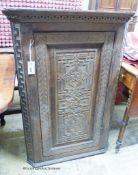 A carved oak hanging corner cupboard, width 70cm, depth 42cm, height 106cm