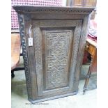 A carved oak hanging corner cupboard, width 70cm, depth 42cm, height 106cm