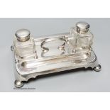 A late Victorian silver inkstand, with handle, pen recesses and two mounted glass wells, on bun