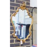A reproduction Rococo style gilt wall mirror W 48, H 82 cms.