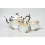 A George V three piece engraved oval silver tea set, C.S. Green & Co, Birmingham, 1924, gross 26oz.