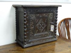 A Charles II carved oak wall cupboard (possibly Dorset),of rectangular form, the single panelled