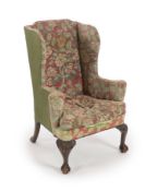 A George III Irish mahogany wing armchair,with outward scroll arms and acanthus carved cabriole