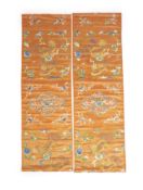 A pair of Chinese peach silk embroidered hangings, 19th centuryeach embroidered with Buddhist lions