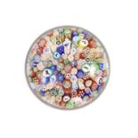 A Baccarat close packed millefiori glass paperweight, dated 1848,with pictorial silhouette canes