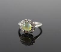 A 1920's/1930's platinum, cats eye chrysoberyl and diamond set oval cluster ring,size H, gross 2.7