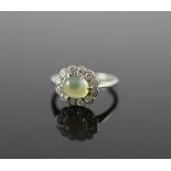 A 1920's/1930's platinum, cats eye chrysoberyl and diamond set oval cluster ring,size H, gross 2.7