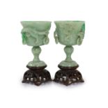 A pair of Chinese small jadeite stem cups, 20th century,each carved in high relief with a chi