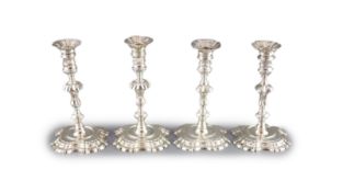 A near set of four George II cast silver candlesticks, by John Cafe,with waisted knopped stems, on