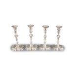 A near set of four George II cast silver candlesticks, by John Cafe,with waisted knopped stems, on