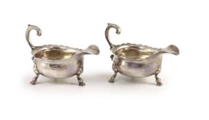 A pair of George II silver sauceboats, by Henry Brind,with flying scroll handles, on hoof feet,