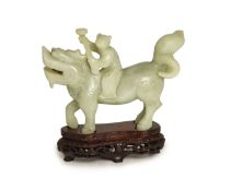 A Chinese pale celadon-grey jade group of a boy riding a qilin, 17th/18th century,13.5cm long, wood