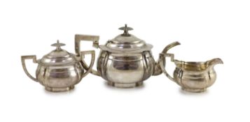 An early 20th century Chinese white metal three piece tea set by Zee Wo,of planished ovoid design,