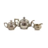 An early 20th century Chinese white metal three piece tea set by Zee Wo,of planished ovoid design,