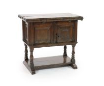 A 17th century rectangular oak drop-flap games table, fitted cupboard and undertierwith twin flap