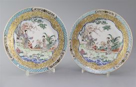 A fine pair of Chinese famille rose plates, Yongzheng period,each painted with two ladies in a