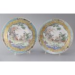 A fine pair of Chinese famille rose plates, Yongzheng period,each painted with two ladies in a