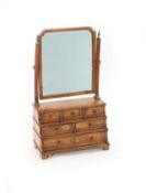A Queen Anne walnut toilet mirror,with later mirror plate over three tiers of six drawers, on