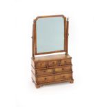 A Queen Anne walnut toilet mirror,with later mirror plate over three tiers of six drawers, on