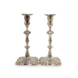 A pair of early George III cast silver candlesticks by William Cafe,with waisted knopped stems, on