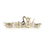 An Edwardian embossed silver circular four piece tea and coffee service by Edward Barnard & Sons