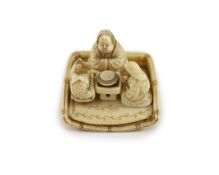 A Japanese ivory netsuke of figures seated around a table, Meiji period,the underside carved with