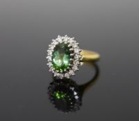 A modern 18ct gold, green tourmaline and diamond set oval cluster ring,size N, gross weight 8