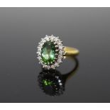 A modern 18ct gold, green tourmaline and diamond set oval cluster ring,size N, gross weight 8