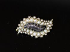 A George IV gold, graduated split pearl and black enamel leaf shaped mourning brooch,with plaited