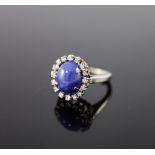 A 14k white gold, cabochon star sapphire and diamond set oval cluster ring,size I, gross weight 5.3
