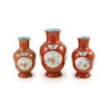 A set of three Chinese coral ground ‘boys’ vases, Jiaqing period (1796-1820),each painted in