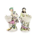 A pair of Meissen figural flower holders c.1755,modelled as a seated lady and gentlemen holding a
