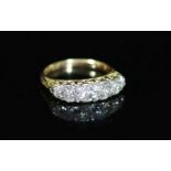 An early 20th century 18ct gold and graduated five stone diamond ring,with diamond chip spacers and