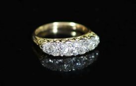 An early 20th century 18ct gold and graduated five stone diamond ring,with diamond chip spacers and
