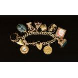 A 1970's 9ct. gold charm bracelet,hung with ten assorted charms, including old telephone, a mounted