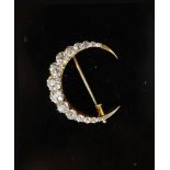 A gold and graduated fifteen stone old round cut diamond set crescent pendant brooch,the largest