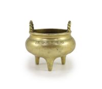 A Chinese bronze tripod censer, 18th/19th century,with a pair of rope twist handles to the rim