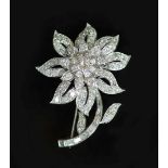 A white gold and diamond encrusted flower brooch,set with round and baguette cut diamonds, the