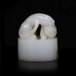 A Chinese white jade oval seal,carved in high relief and open work with a lion-dog, four character