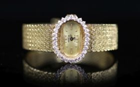 A lady's modern Swiss 14k gold and diamond set manual wind oval wrist watch, on integral 14k gold