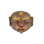 A Tibetan painted repoussé copper ‘demon’ mask, 17th/18th century,with fierce expression,28cm wide,